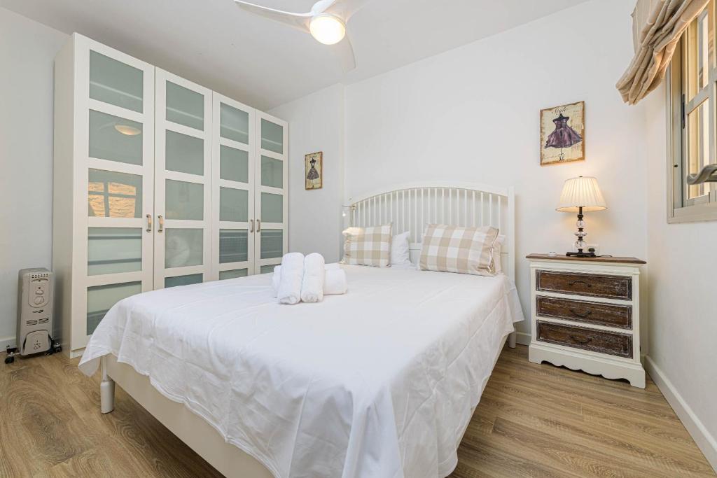 biała sypialnia z białym łóżkiem i komodą w obiekcie WintoWinRentals Genial Apartamento, Céntrico y Silencioso w Maladze