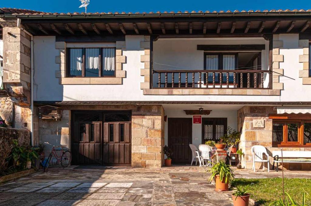 a house with a balcony and a patio at Casa rural Paco En pleno corazón de Cantabria muy cerca de la costa in Carranceja