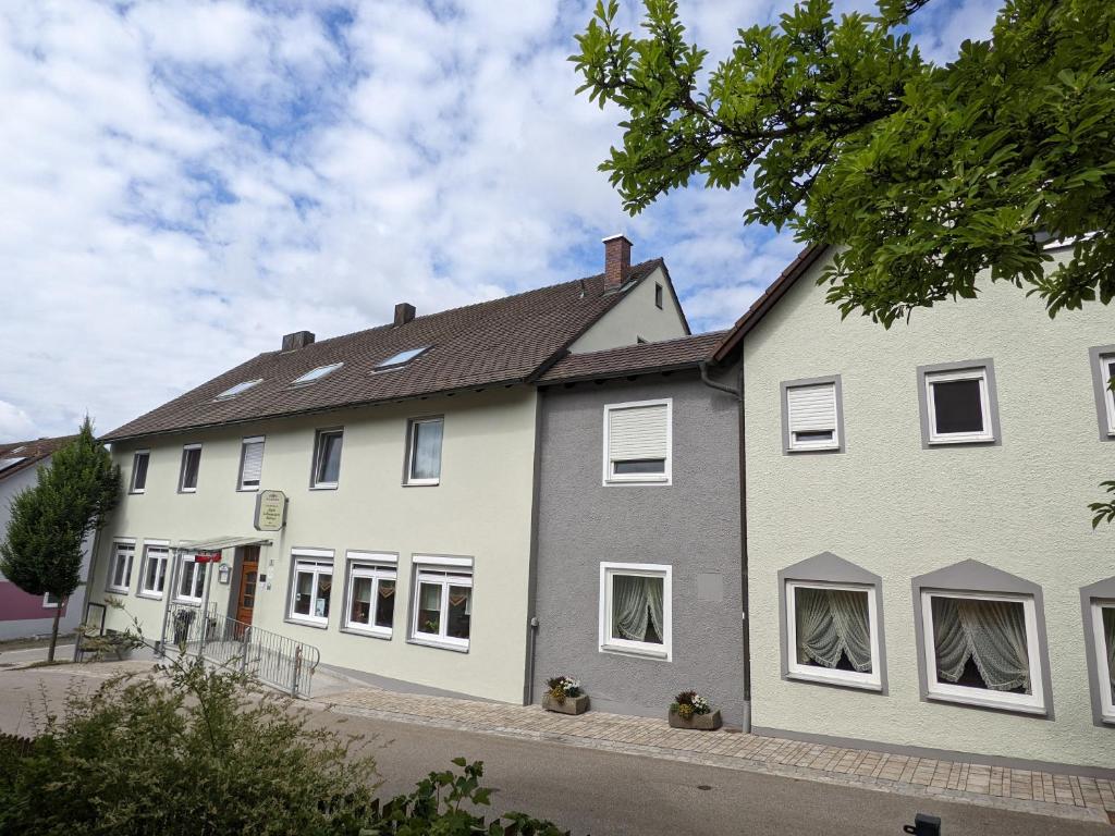 Casa blanca con ventanas blancas en una calle en Zum Schwarzen Bären, en Vohenstrauss