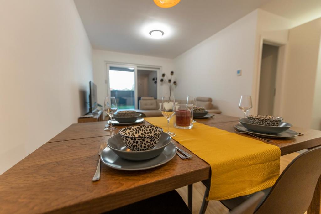 uma sala de jantar com uma mesa com pratos e copos em Apartment LaSiesta em Ptuj