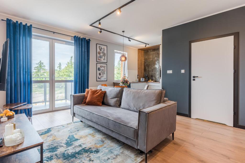 ein Wohnzimmer mit einem Sofa und einer Küche in der Unterkunft Sapphire Premium Apartment in Graudenz