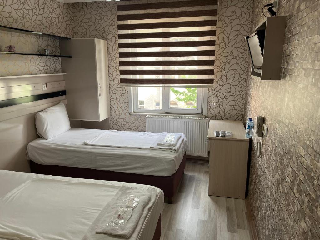 mały pokój z 2 łóżkami i oknem w obiekcie Balkan Palace Edirne w mieście Edirne