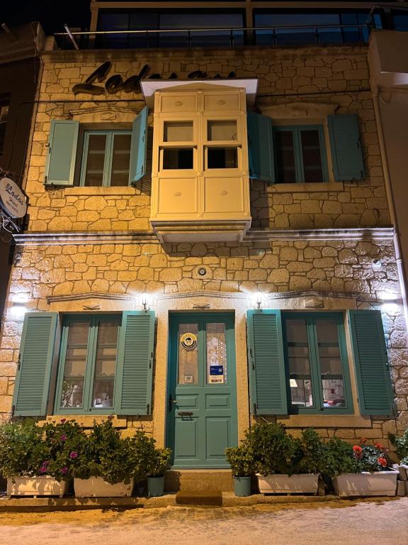 a building with green shutters and a window at Lodos Butik Hotel in Alaçatı