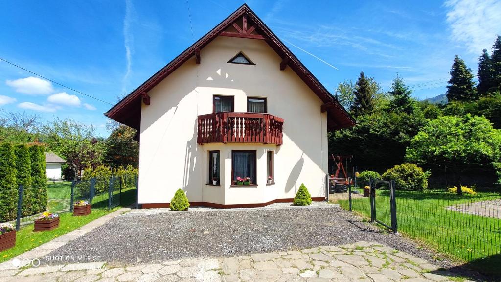 a small white house with a balcony on top at Dom u Gazdy przy Gondoli in Szczyrk