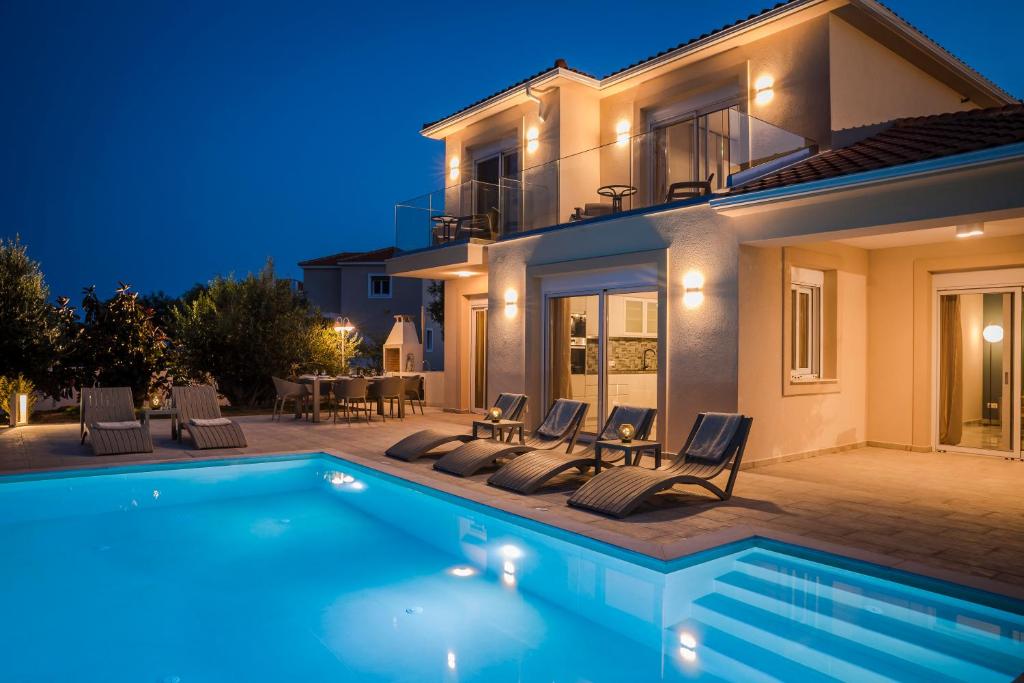 a villa with a swimming pool at night at Montagna & Mare villa in Kefallonia