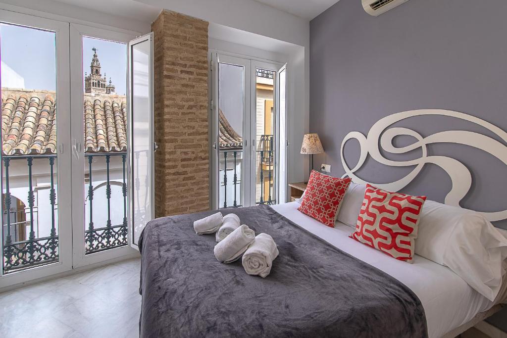 um quarto com uma cama grande e toalhas em Reservaloen Mariano de Cavia em Sevilha