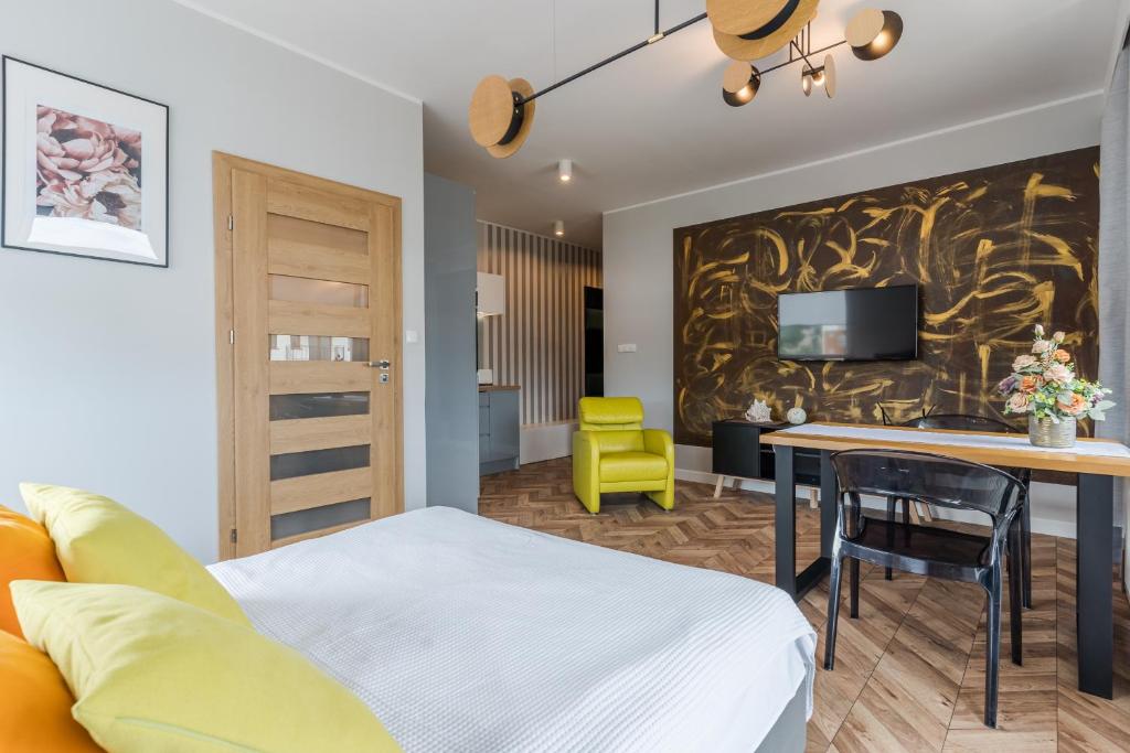 sypialnia z łóżkiem i stołem z żółtym krzesłem w obiekcie Copper Apartment w Grudziądzu