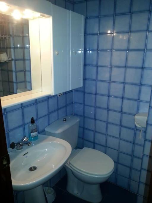 niebieska kafelkowa łazienka z toaletą i umywalką w obiekcie Precioso piso duplex en la Bahia de Cadiz para 5 plazas w mieście Puerto Real
