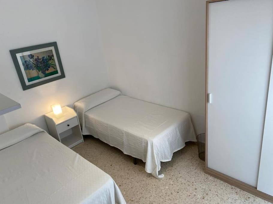 mały pokój z 2 łóżkami i lustrem w obiekcie Precioso piso duplex en la Bahia de Cadiz para 5 plazas w mieście Puerto Real