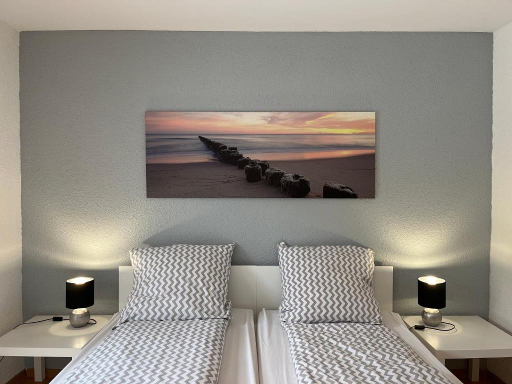 a bedroom with two beds and a picture on the wall at Willa Mare in Dębki