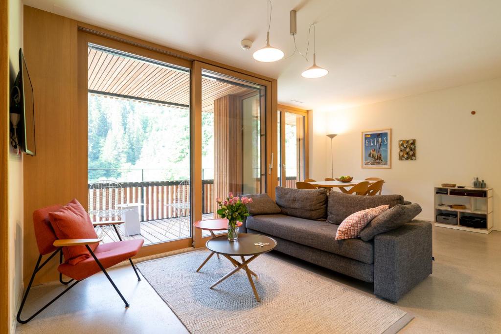 uma sala de estar com um sofá e uma mesa em Edelweiss Stenna Selva em Flims