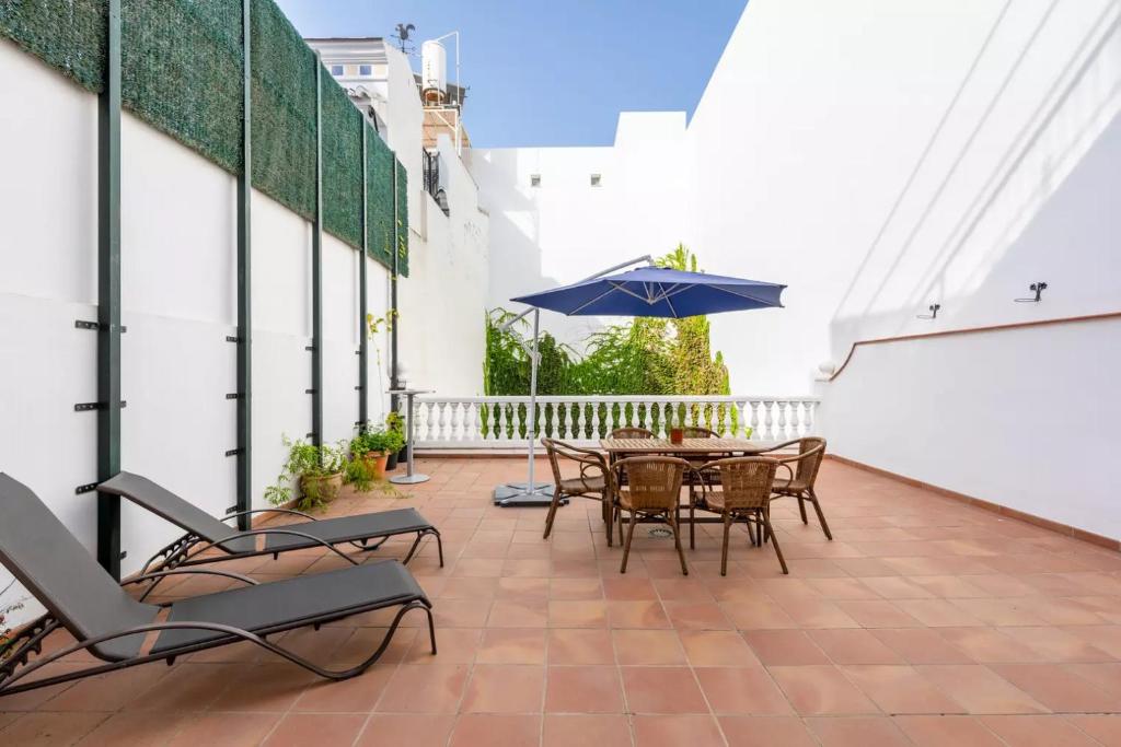 een patio met een tafel en stoelen en een parasol bij Casa sol in Vélez-Málaga