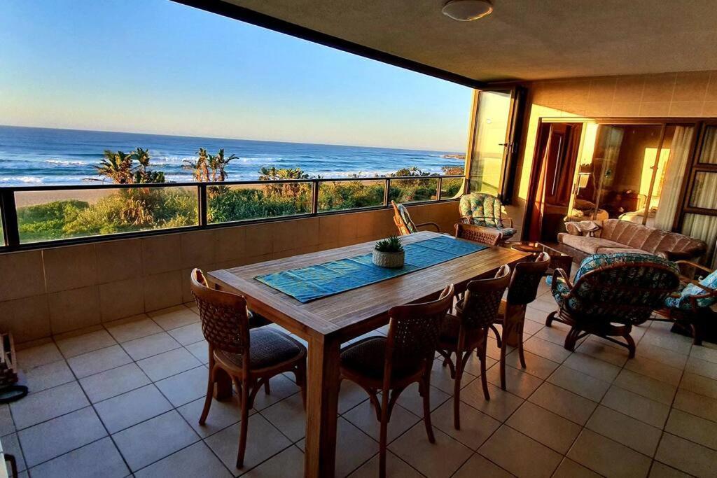 een eetkamer met een tafel en uitzicht op de oceaan bij Juanita 202 Margate North Beach in Margate