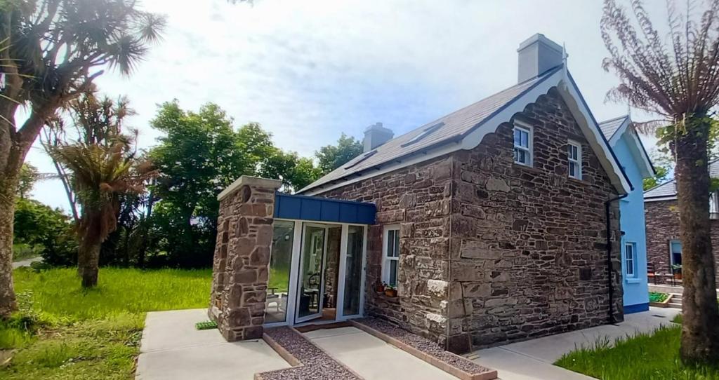 mały kamienny dom z niebieskim dachem w obiekcie Dingle Woodland Cottage w mieście Dingle