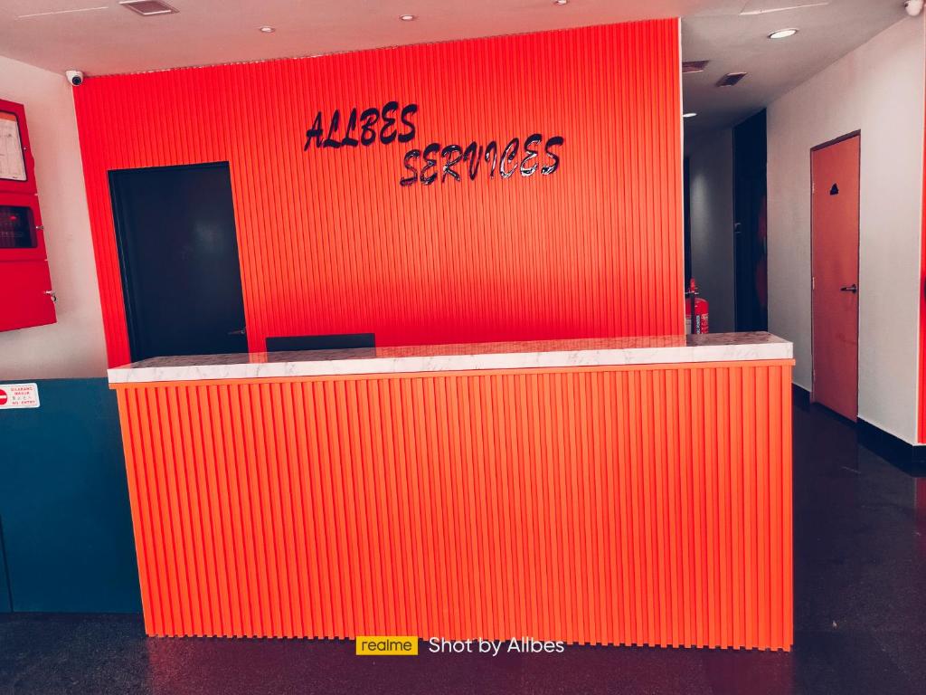 uma parede laranja com as palavras beijar serviços nela em Allbes Parklands Hotel em Klang
