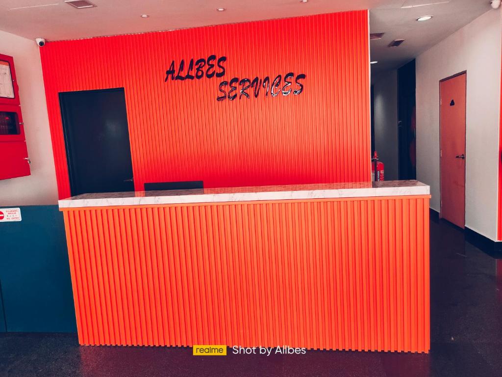 an orange wall with the words kiss services on it at Allbes Parklands Hotel in Klang