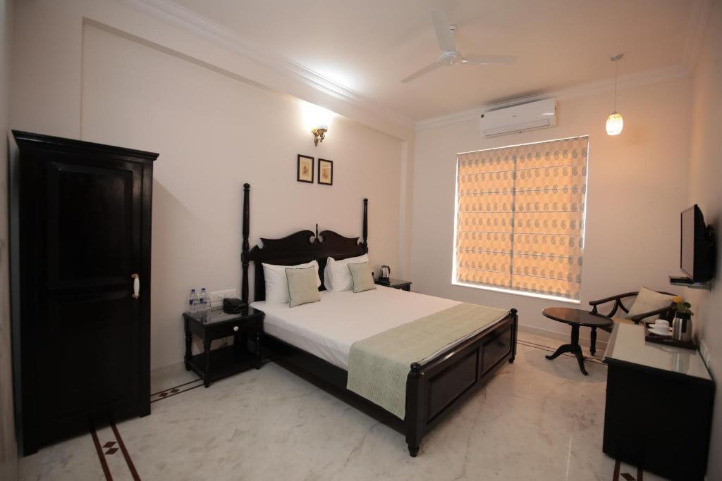 1 dormitorio con cama y ventana en Jai Villa - A Boutique Hotel, en Jaipur