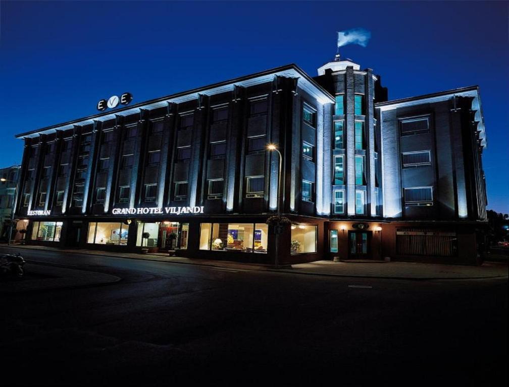 un grand bâtiment avec un panneau à l'avant dans l'établissement Grand Hotel Viljandi, à Viljandi