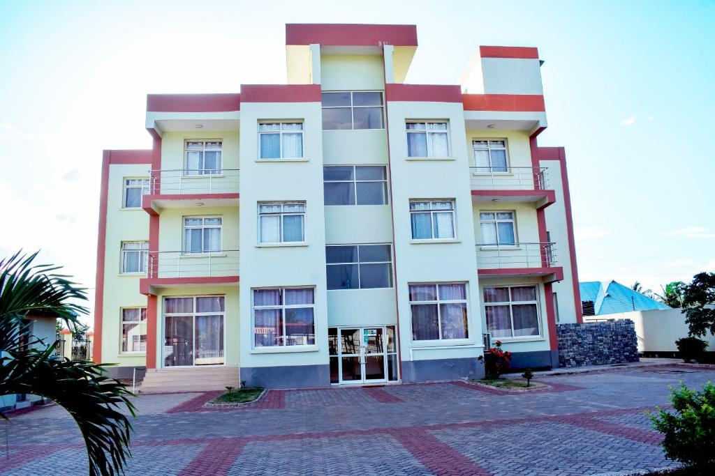 un edificio alto de color blanco con muchas ventanas en Ambiere House en Mtwara