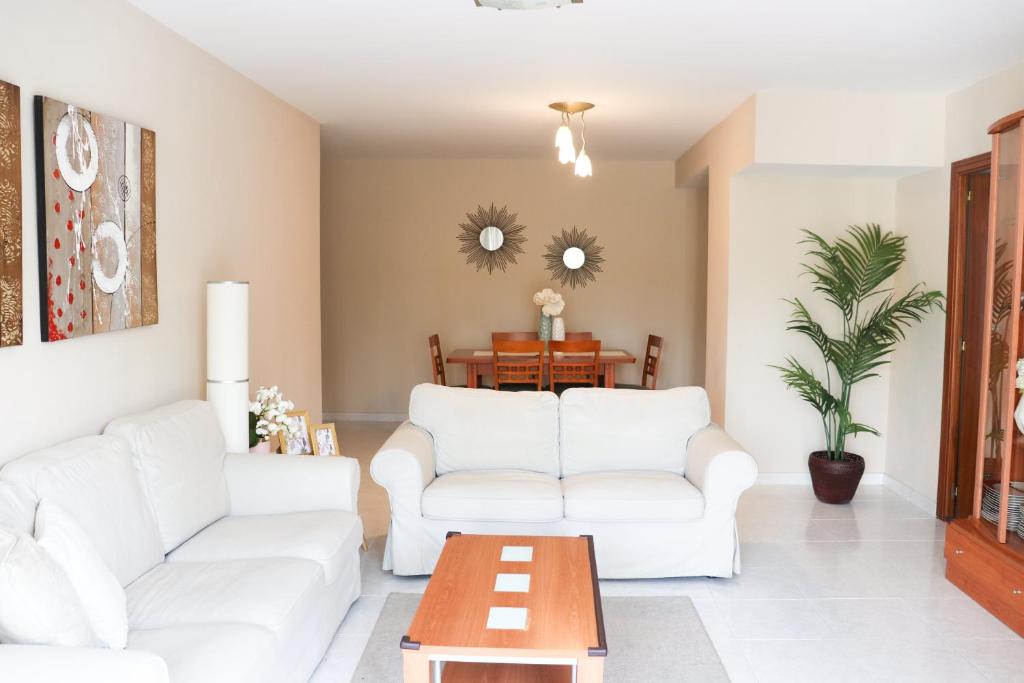 un soggiorno con due divani bianchi e un tavolo di Apartamento Dos Valles ad Aínsa