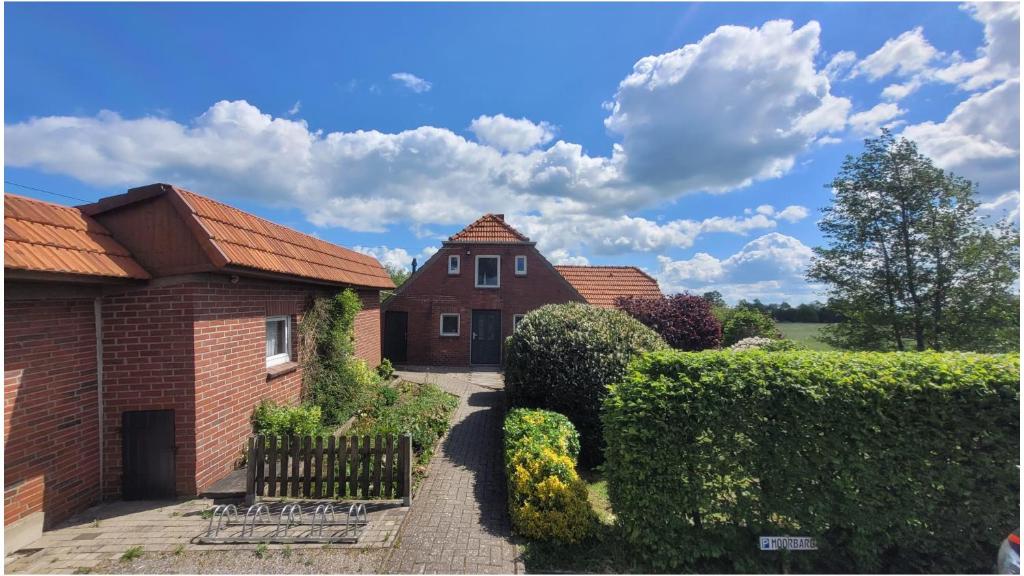 a house with a hedge in front of a house at MoorBarg + MoorPütt in Sehestedt