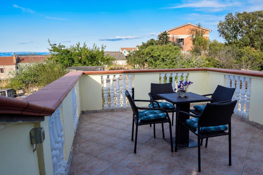 eine Terrasse mit einem Tisch und Stühlen auf dem Balkon in der Unterkunft Apartman Bella vista in Veli Iž
