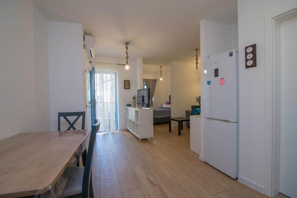 a kitchen and living room with a table and a refrigerator at Pinea in Veli Lošinj