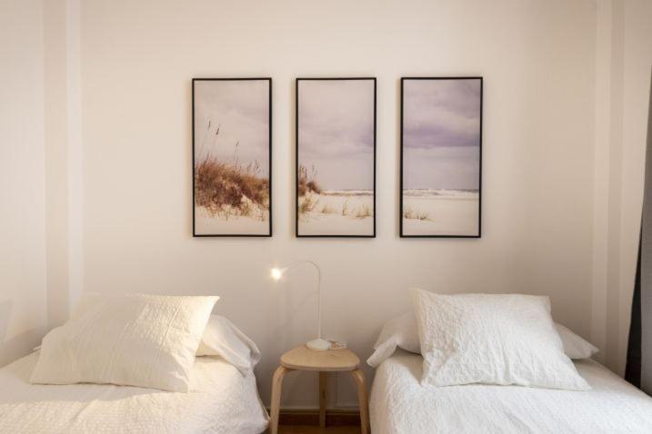 vier foto's aan een muur boven twee bedden bij Precioso apartamento en Lanzarote, zona Arrecife - El Charco de San Ginés in Arrecife