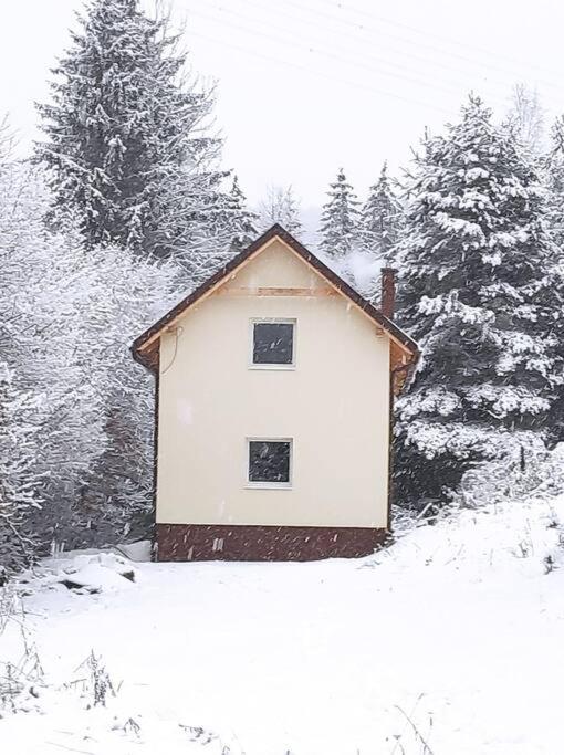 a small white house in the snow with trees at Komplet vybavená chata s Wi+TV prírodnom prostredí 