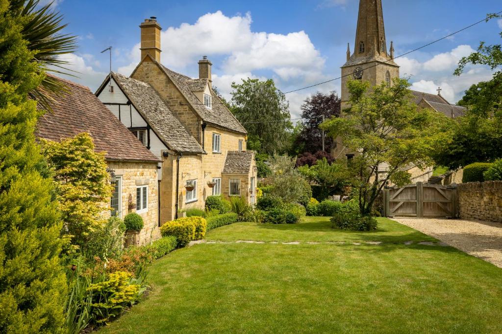 an old house with a green yard in front of it at Blenheim Cottage, Beautiful 15th Century Cotswold Cottage, 4 Bed, Nr Chipping Campden in Mickleton