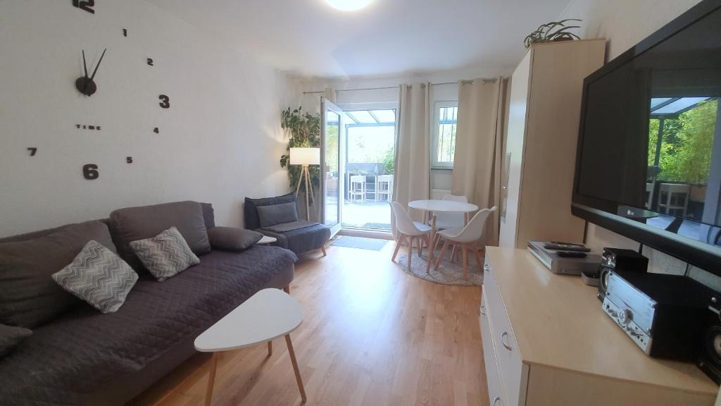 a living room with a couch and a television at City Apartment Hanau in Hanau am Main