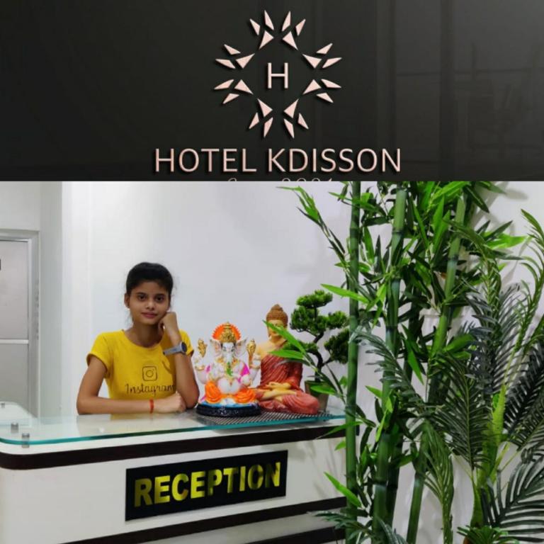 a young boy sitting on a table in a hotel lobby at Hotel KDISSON in Mohaniā