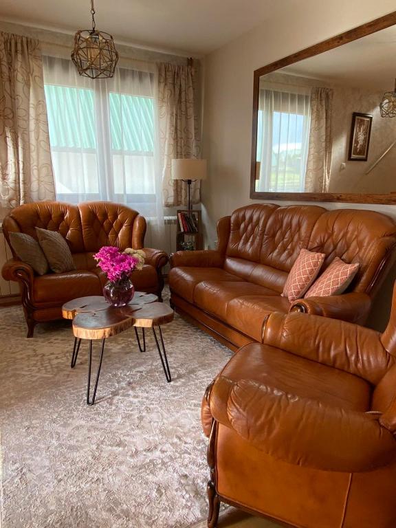 a living room with brown leather couches and a table at White Home in Žabljak