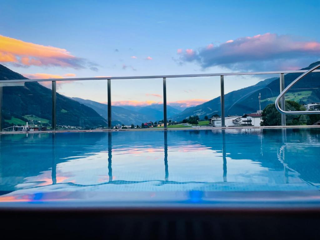 a swimming pool with a view of the mountains at Hotel Malerhaus in Fügen