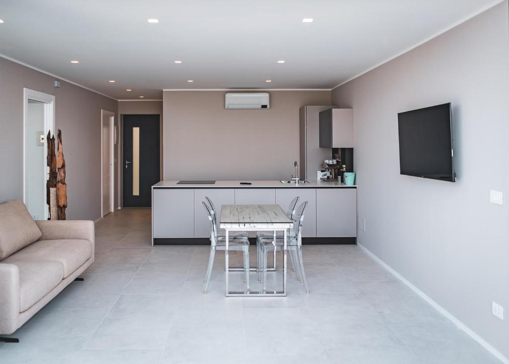 a kitchen and living room with a table and a couch at Seaside Resort in Trieste