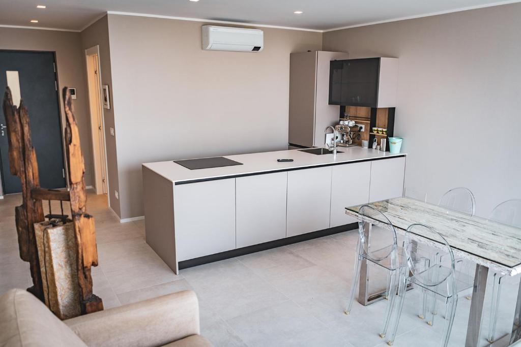 a kitchen with white cabinets and a table in it at Seaside Resort in Trieste