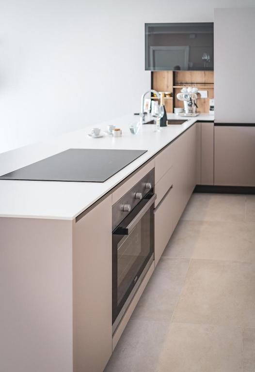 a white kitchen with a sink and a refrigerator at Seaside Resort in Trieste