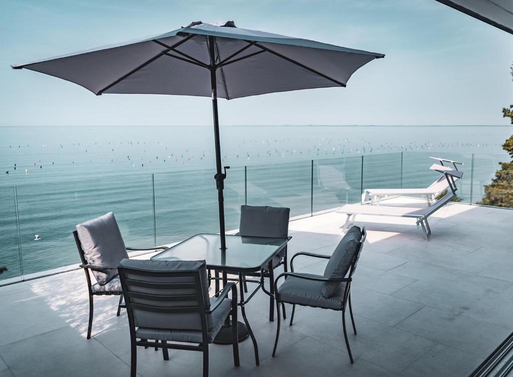 a patio with a table and chairs and an umbrella at Seaside Resort in Trieste