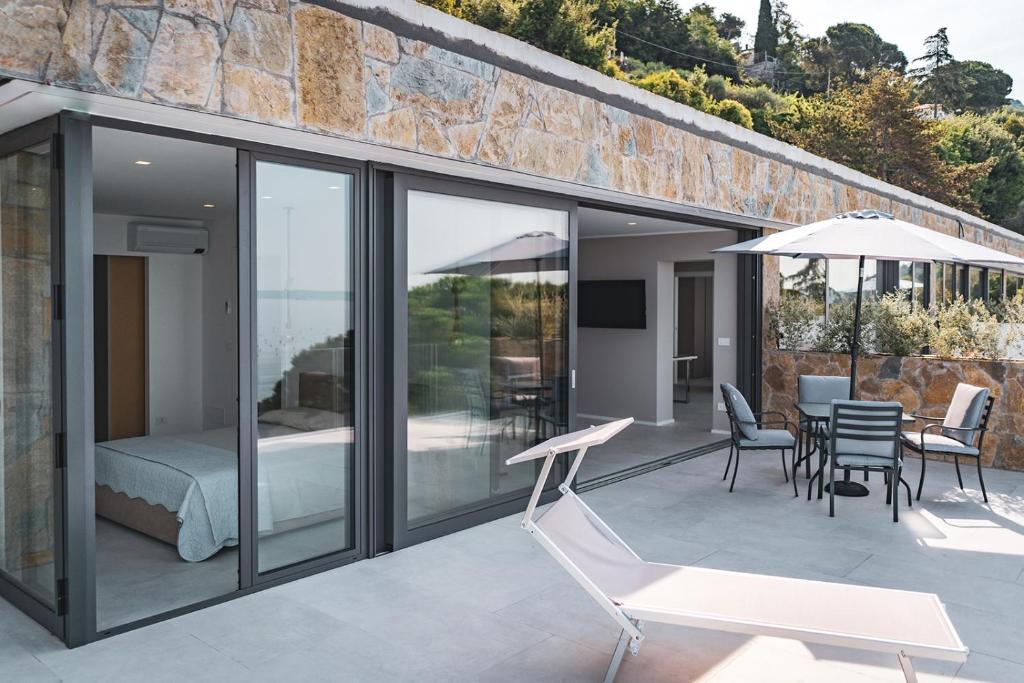 a glass house with a bed and a patio at Seaside Resort in Trieste