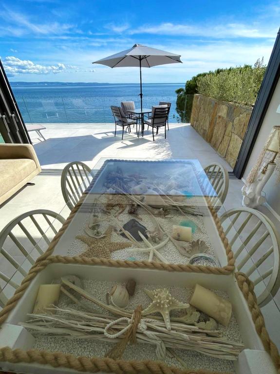 a table with a glass top with a view of the ocean at Seaside Resort in Trieste