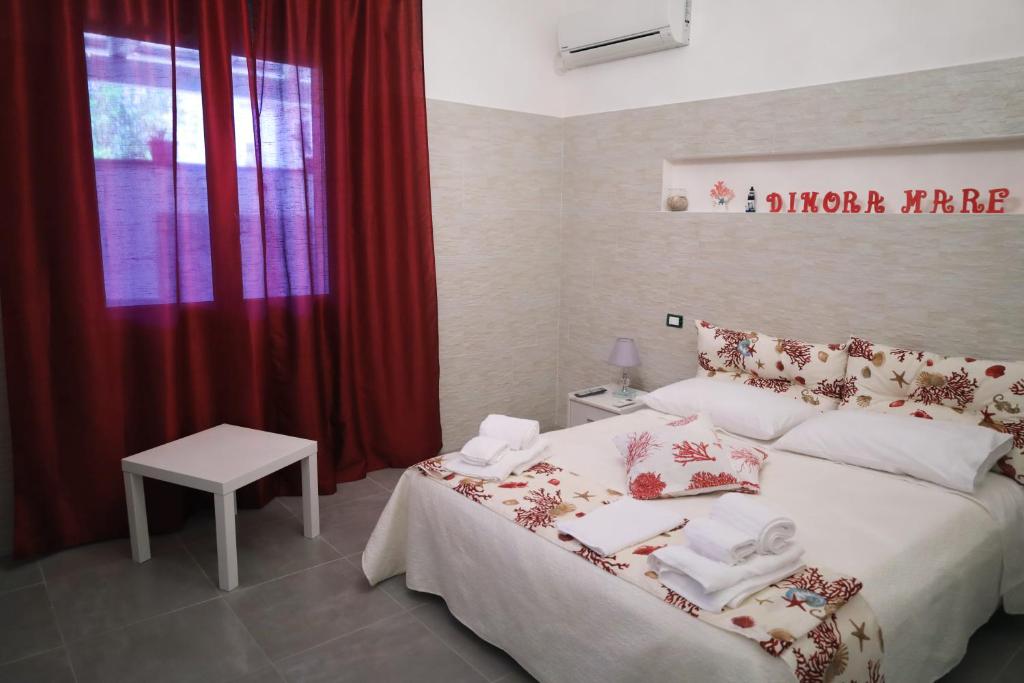 una camera da letto con un grande letto con tende rosse di Dimoramare a Tonnara di Bonagia