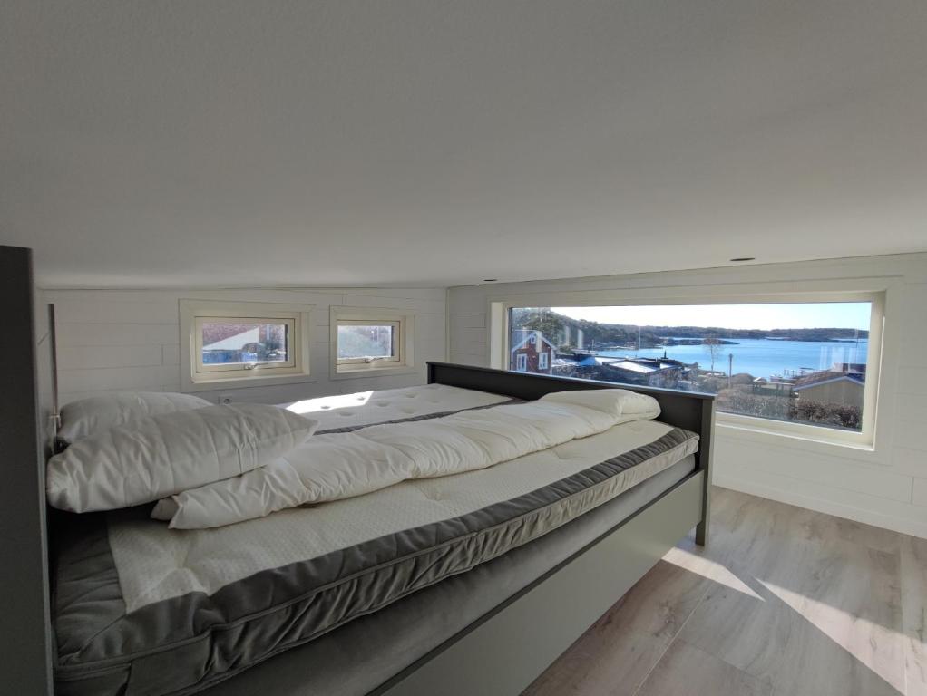 Cama en habitación con ventana grande en New villa, 45sqm, 2 bedrooms, loft, 80m from beach, fantastic views & very quiet area, en Onsala