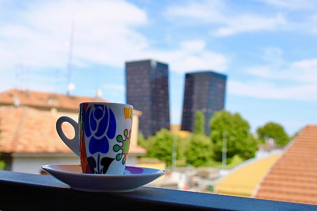 eine Kaffeetasse und eine Untertasse, die auf einem Fensterbrett sitzt in der Unterkunft Rho Fiera Milano - Popy House in Pero