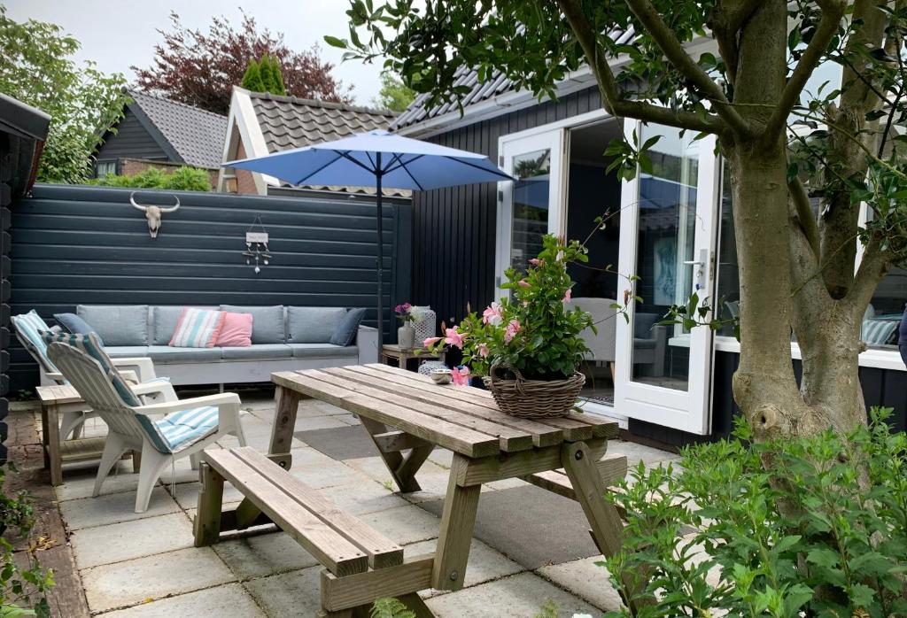 a patio with a picnic table and an umbrella at Appelbloesem in Bergen