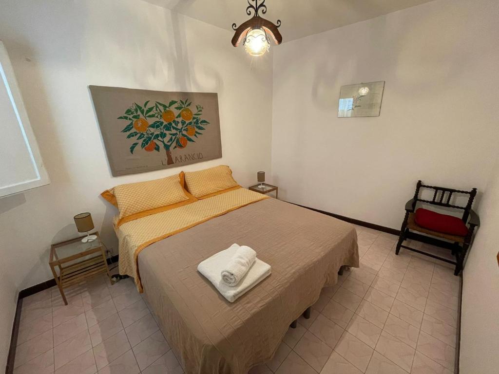 Un dormitorio con una cama con una toalla. en Cortile Via Sales 11, en Erice