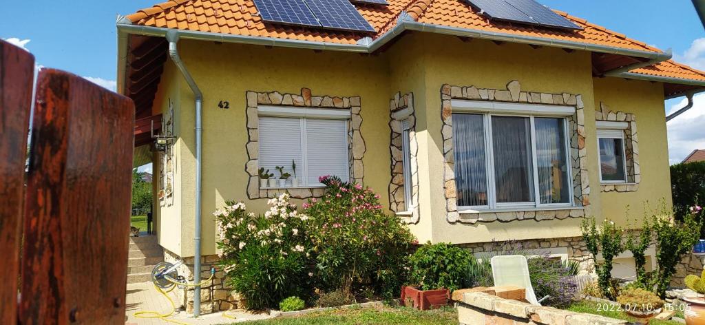 a small yellow house with solar panels on the roof at Barackos Apartman in Tapolca
