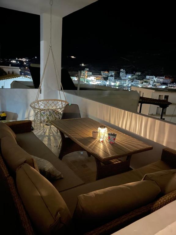 ein Tisch und ein Sofa auf einem Balkon in der Nacht in der Unterkunft Aegean Breeze Kythnos Greek small apartment in Mérikhas