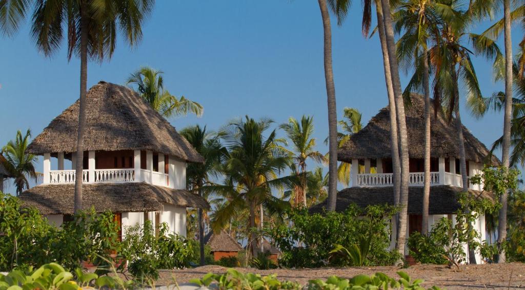 two resorts on the beach with palm trees at Kijongo Bay Beach Resort in Pangani