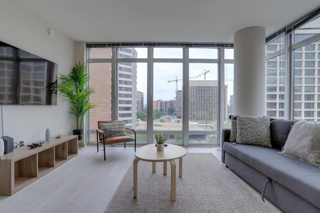 uma sala de estar com um sofá e uma mesa em Wonderful 2BR Condo At Crystal City With Rooftop em Arlington