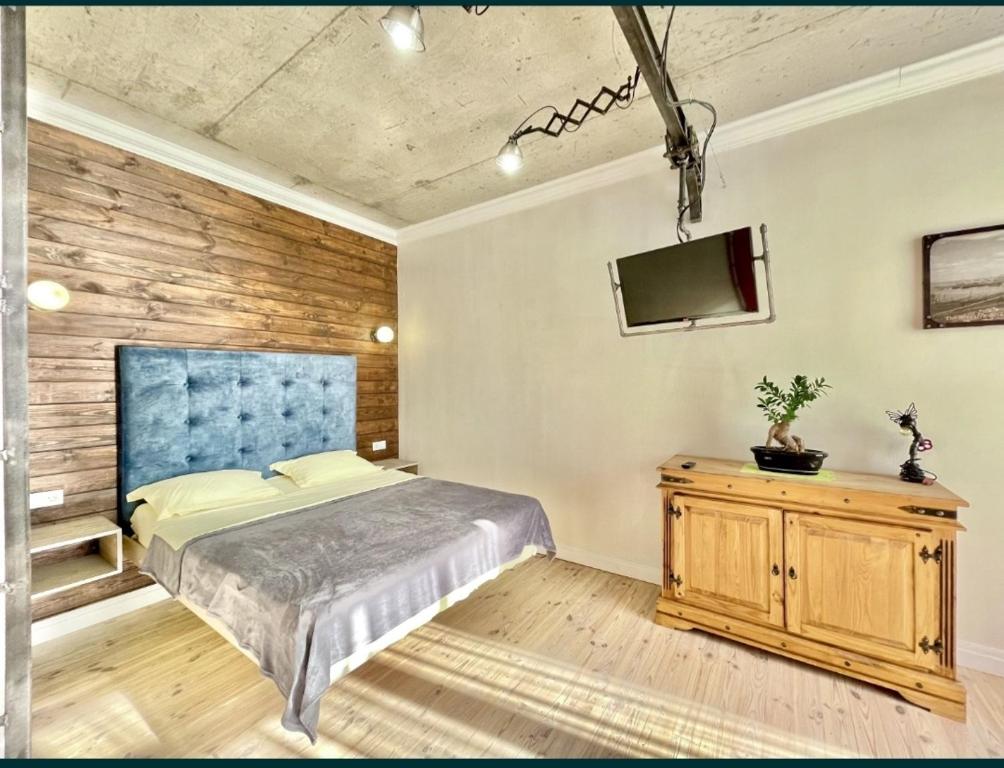 a bedroom with a bed and a tv on a wall at Лофт с гамаком с видом моря в 9 Жемчужине в Аркадии, Кадор in Odesa